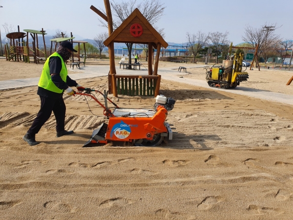 서울시 한강사업본부 직원이 한강공원 내 모래놀이터의 이물질을 제거하고 있다. 사진=서울시